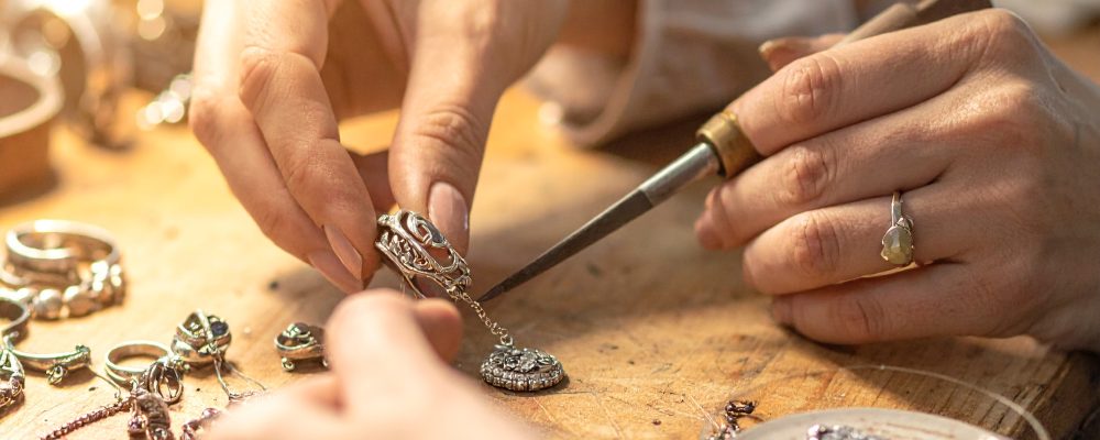 Firefly_Close-up photo of an artisan’s hands carefully shaping and polishing 925 silver jewel 324885