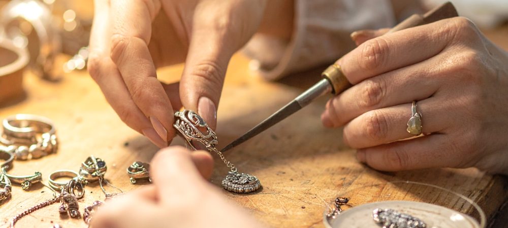 Firefly_Close-up photo of an artisan’s hands carefully shaping and polishing 925 silver jewel 324885